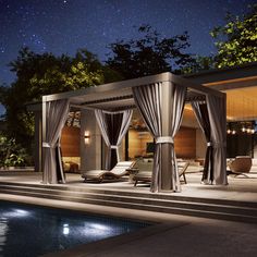 an outdoor living area next to a pool at night