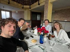 a group of people sitting at a table with wine glasses and food in front of them