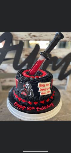 a black and red cake with a knife sticking out of it