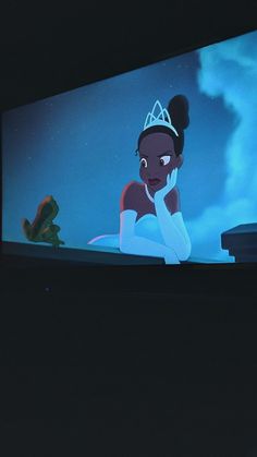 a cartoon character sitting in front of a tv screen with a frog on it's lap