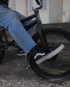 a person is riding a bike on the street with their feet propped up against the handlebars