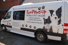 a white van parked in front of a house with a dog and cat on it