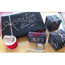 three wrapped presents sitting on top of a cutting board next to scissors and twine