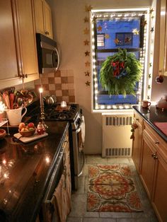 a kitchen filled with lots of counter top space next to a window covered in christmas lights