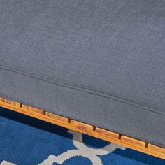 a close up of a blue rug with a wooden frame on the bottom and sides