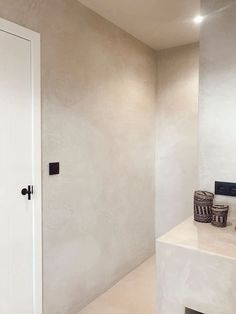 a bathroom with a sink and mirror next to a white door in the middle of it