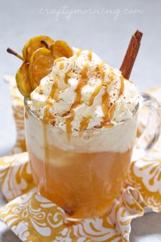 an apple cider float is garnished with whipped cream and cinnamon