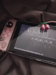 an image of a game being played on a cell phone with two cherries attached to the screen