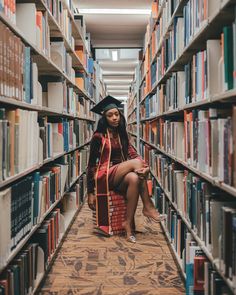 a woman is sitting on the floor in a library with bookshelves full of books