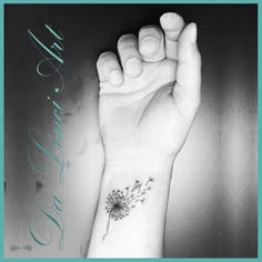 a black and white photo of a hand with a flower tattoo on it's wrist