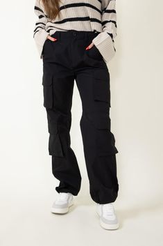 Step up your athletic game this with these Love Tree Baggy Cargo Pants for Women in Black. These pants feature a comfy parachute design, elastic waistband, and cargo pockets to keep you comfortable all day long. These are going to be your new favorite pair of pants! Features: Love Tree Style: 6870PN-BLACK Color: Black 100% Nylon Women’s pants Zipper and button fly Belt loop Elastic back waistband Hand pockets Double cargo pockets Fake pocket flaps Adjustable toggles at hem of each pantleg Loose Womens Baggy Pants Outfit, What To Pair With Parachute Pants, Women’s Cargo Pants, Black Utility Pants Outfit, Black Cargo Sweatpants Outfit, Black Carpenter Pants Outfit, Black Cargo Pants Outfit Women Casual, Cargo Pants With Sneakers, Baggy Black Pants Outfit