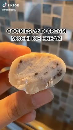 a hand holding a cookie and cream mochi ice cream