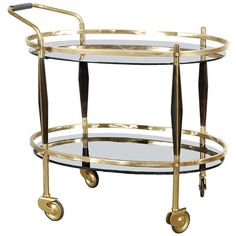 a glass and brass serving cart with wheels