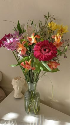 a vase filled with lots of different colored flowers