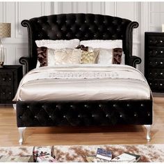 a bed with black headboard and foot board in a room next to other furniture