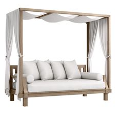 a white couch with pillows on top of it and a canopy bed in the middle