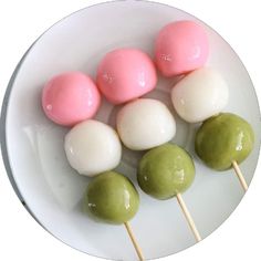 there are four different types of marshmallows on a white plate with green and pink