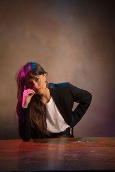 a woman sitting at a table with her hands on her head