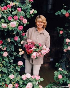 a woman is standing in front of some flowers