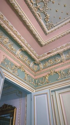 an ornately decorated ceiling in the corner of a room with blue walls and gold trim