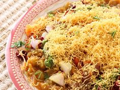 a plate filled with rice and vegetables on top of a tablecloth covered place mat