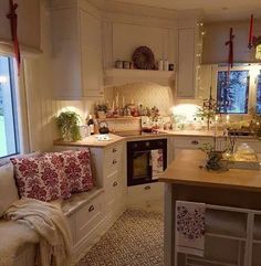 a kitchen filled with lots of counter top space and white cabinets next to a window