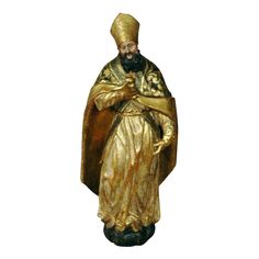 a statue of an old man with a beard and wearing a golden outfit, standing in front of a white background