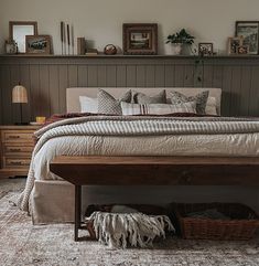 a bedroom with a bed, dressers and rug on the floor in front of it