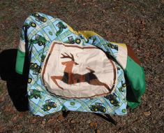 a child's diaper with a deer on it sitting in the grass next to a bag