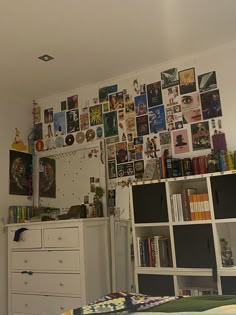 a bed room with a neatly made bed and lots of pictures on the wall