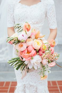 a bride holding a bouquet of flowers in her hands