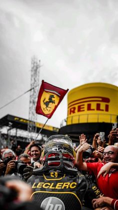 a man in a helmet is surrounded by fans