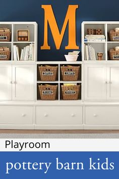 a white bookcase with drawers and baskets in front of a wall mounted letter m