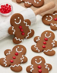 gingerbread cookies decorated with icing and sprinkles on a white surface