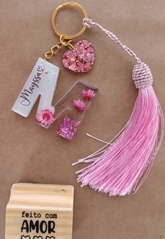 a pink tassel and keychain are sitting on a table