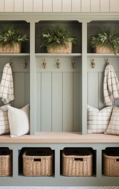 a bench with baskets and plants on it in front of two coats of coat hooks