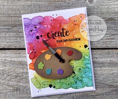 a close up of a card with a paint palette and the words create your own rainbow on it