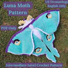 a crocheted blue and purple butterfly on the grass with instructions to make it