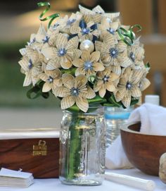 a vase filled with flowers sitting on top of a table next to a wooden bowl