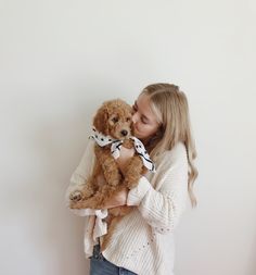 a woman holding a brown dog in her arms