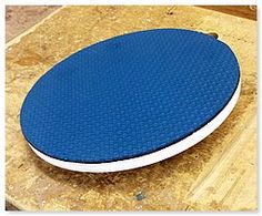 a blue and white frisbee sitting on top of a wooden table next to a piece of wood