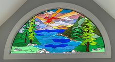 a stained glass window with trees and water in it