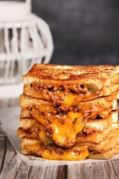 a grilled cheese sandwich stacked on top of each other with meat and melted cheese