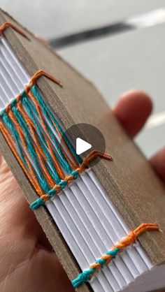 someone is stitching an orange and blue piece of fabric