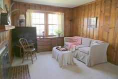 a living room with wood paneling and furniture