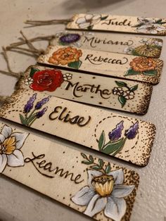 four wooden name tags with flowers on them