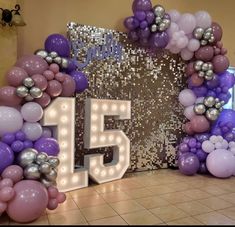 a large number 15 surrounded by balloons and streamers