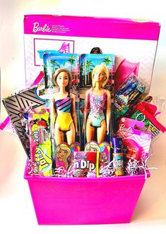 a barbie doll in a pink box filled with assorted items