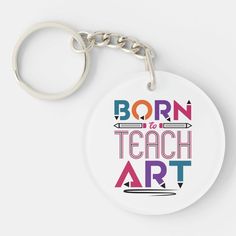 a keychain with the words born to teach art in multicolored letters