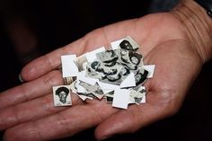 a person's hand holding small pieces of paper with pictures on them